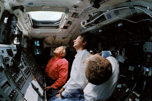 Astronauts Bruce McCandless, Steve Hawley and Loren Shriver peer through the flight deck windows during pre-flight training. Photo Credit: NASA