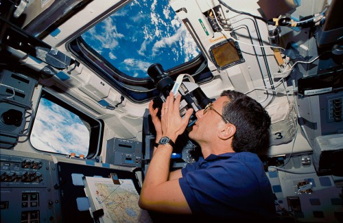 Jay Apt performs Earth resources photography through Endeavour's flight deck windows. Photo Credit: NASA