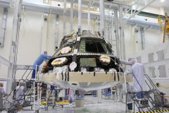 Lockheed Martin technicians and engineers attach the heat shield to the Orion crew module inside the Operations and Checkout Building high bay at NASA's Kennedy Space Center in Florida. Photo Credit: NASA/Daniel Casper