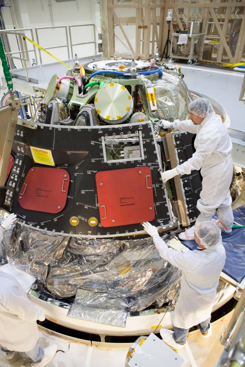Lockheed engineers install the protective back shell tiles on the agency's Orion spacecraft for the EFT-1 mission next Dec. Photo Credit: NASA