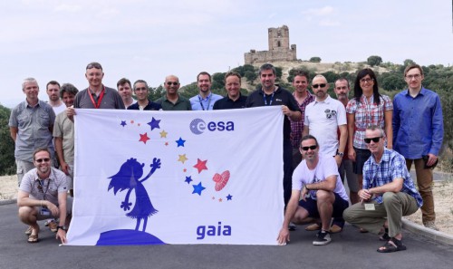 Members of the Gaia Science Operations Centre team at the European Space Astronomy Centre in Madrid, Spain, pose with the mission's flag following its symbolic handover on 18 July, which marked the start of nominal science operations. Image Credit: ESA