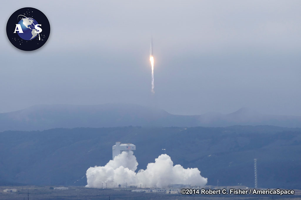 The Atlas V climbs away from the mountain-ringed Vandenberg landscape into a cloud deck, seconds after liftoff. Photo Credit: Robert C. Fisher/AmericaSpace