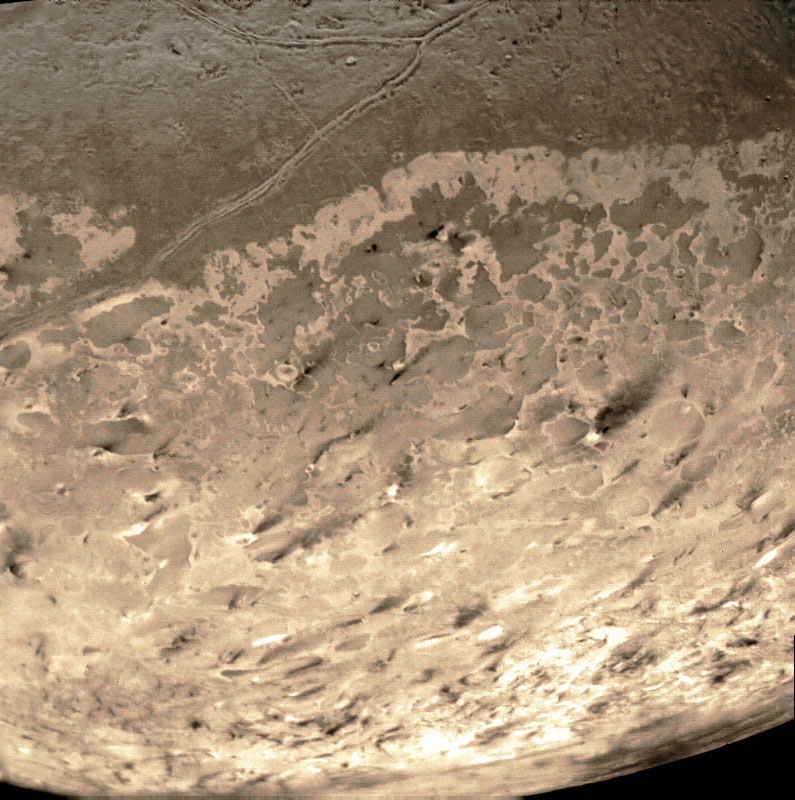 Dark deposits on Triton's polar cap, possibly caused by the action of cryovolcanic geysers. Photo Credit: NASA