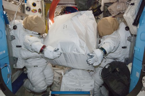 Two Extravehicular Mobility Units (EMUs) in the Quest Airlock. The need to replace long-life batteries aboard the space suits has obliged NASA to postpone a pair of EVAs until no earlier than late September. Photo Credit: NASA