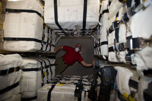 Clad in mask and goggles, Alexander Gerst navigates his way around the interior of the ATV-5 spacecraft. Photo Credit: NASA