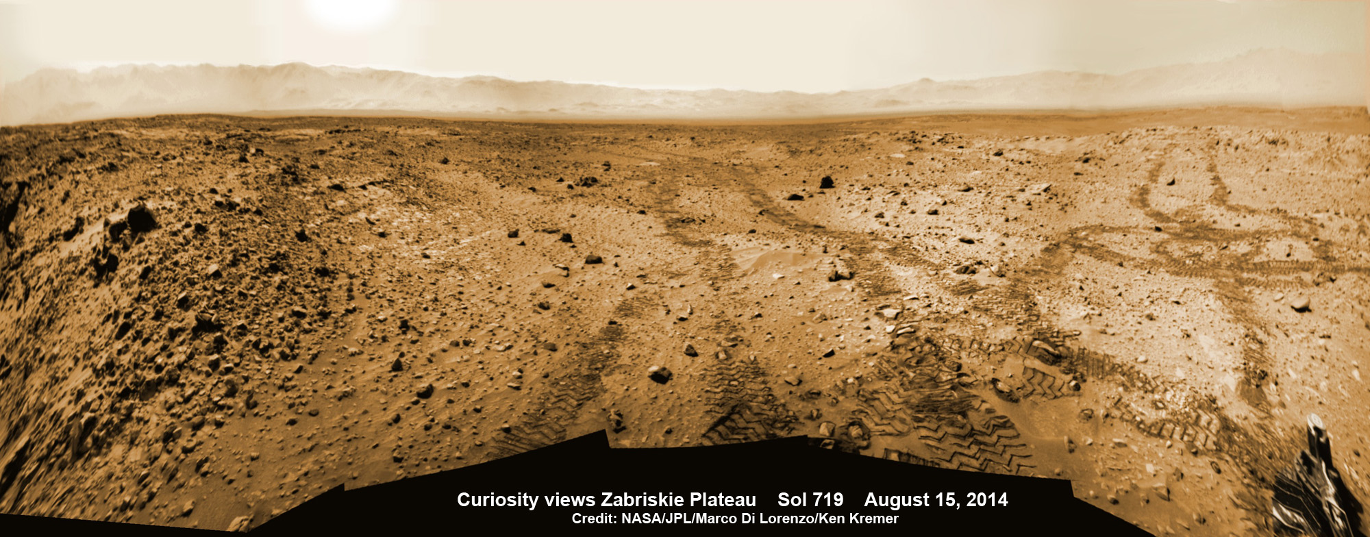 Curiosity rover looks back to the rocky plains of the Zabriskie plateau from sandy ramp into ‘Hidden Valley’ as shown in this photo mosaic view captured on Aug. 14, 2014, Sol 719.  Sharp edged rocks at Zabriskie ripped new holes into rover wheels.   Navcam camera raw images stitched and colorized.  Credit: NASA/JPL-Caltech/Marco Di Lorenzo/Ken Kremer-kenkremer.com