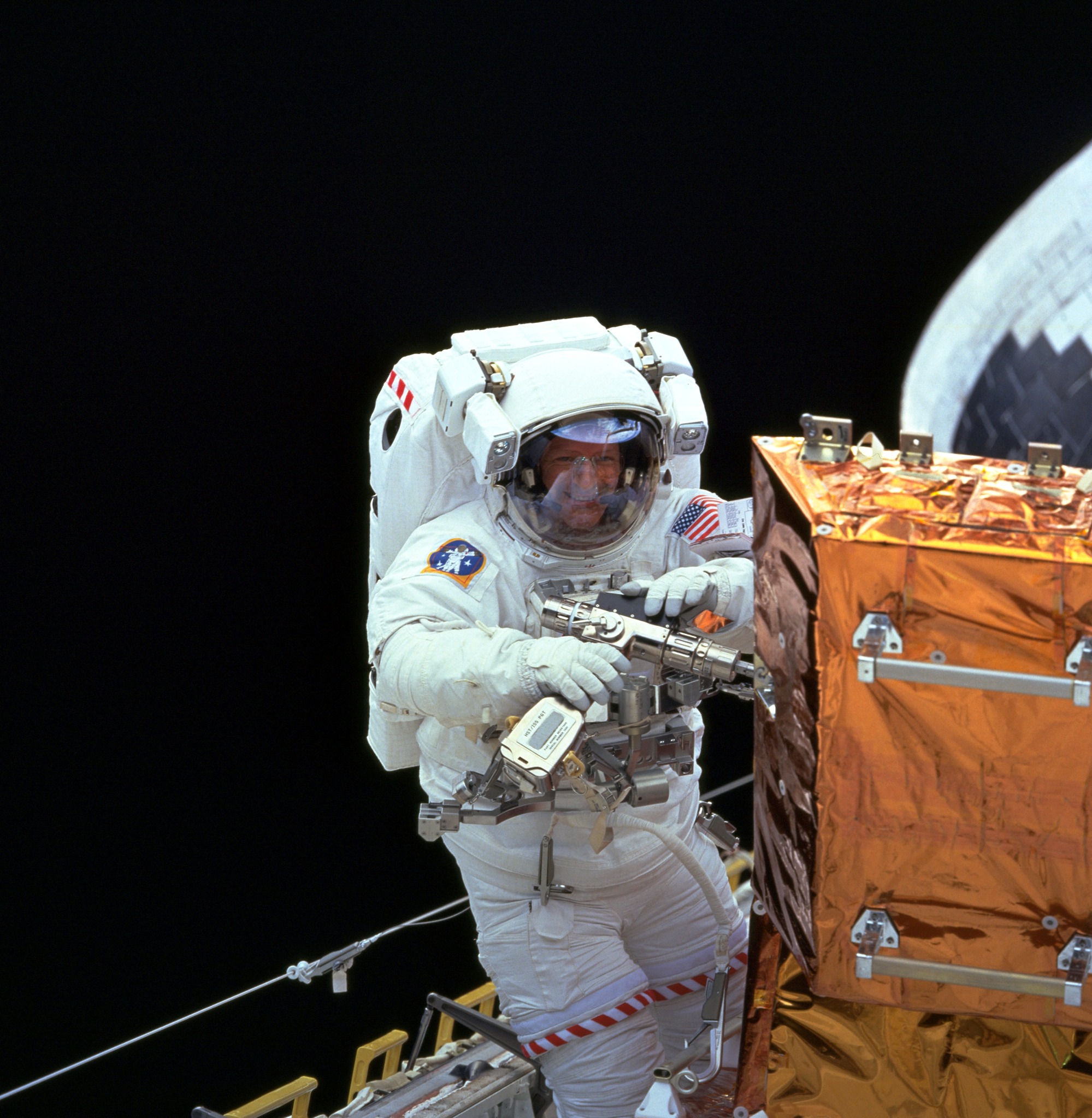 Despite being Switzerland's first spacewalker, Claude Nicollier wore a U.S. flag (as opposed to the Swiss flag) on the arm of his space suit during his EVA to service the Hubble Space Telescope (HST) in December 1999. Photo Credit: NASA