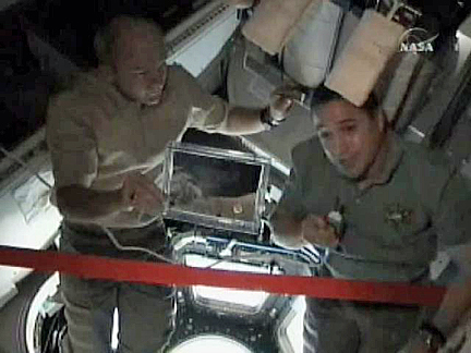 Expedition 22 Commander Jeff Williams (left) and STS-130 Commander George Zamka, inside the newly-installed cupola, pay homage to Lacy Veach in February 2010. Photo Credit: NASA TV