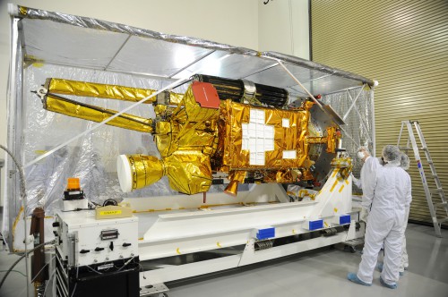 NASA's SMAP spacecraft comes into view as the protective covering is removed in the Astrotech payload processing facility on Vandenberg Air Force Base during a post-shipment inspection. Image Credit: NASA