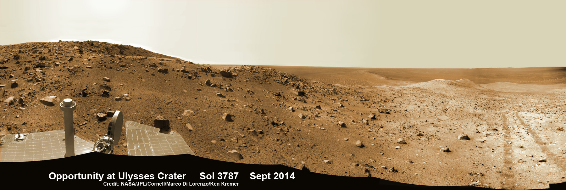 NASA’s Opportunity Mars rover peers out towards Ulysses crater, ejecta rocks and Martian plains beyond  from her Endeavour crater rim location on Sept. 18, 2014.   Notice dramatic wheel tracks (right) as rover ascends steep crater slopes. This navcam camera photo mosaic was assembled from images taken on Sol 3787, Sept. 18, 2014 and colorized.  Credit: NASA/JPL/Cornell/Marco Di Lorenzo/Ken Kremer - kenkremer.com