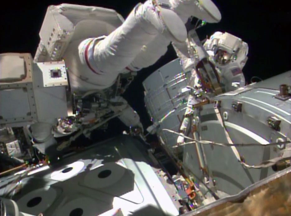 Expedition 41 astronauts Reid Wiseman (top) and Barry "Butch" Wilmore (right) work at the zenith face of the Harmony node during yesterday's EVA-28. Photo Credit: NASA