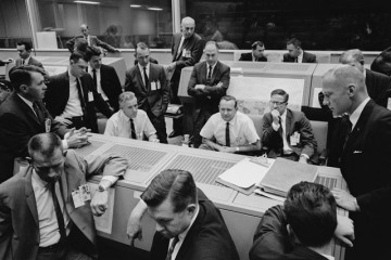 A sea of grim faces surround Flight Director Chris Kraft in the Manned Spacecraft Center (MSC) in Houston, Texas, in the aftermath of the Atlas-Agena malfunction in October 1965. Photo Credit: NASA
