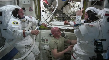 Barry "Butch" Wilmore (left) and Reid Wiseman (right) work with crewmate Alexander Gerst in the Quest airlock to resize their space suits in order to accommodate the gradual lengthening of the spine in microgravity. Photo Credit: NASA
