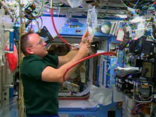 Commander Barry Wilmore is in the Destiny lab module filling a water bag. Credit: NASA TV