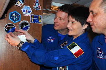 Samantha Cristoforetti proudly displays her mission's "Futura" patch, as Terry Virts (left) and Anton Shkaplerov look on. Photo Credit: NASA