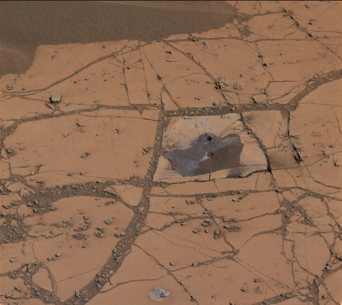 This image shows the first holes drilled by NASA's Mars rover Curiosity at Mount Sharp. The loose material near the drill holes is drill tailings and an accumulation of dust that slid down the rock during drilling.  Credit: NASA/JPL-Caltech/MSSS