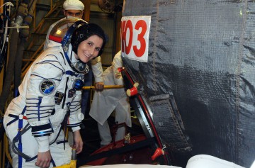 Samantha Cristoforetti, clad in her Sokol ("Falcon") launch and entry suit, examines the Soyuz TMA-15M spacecraft at Baikonur. Photo Credit: NASA