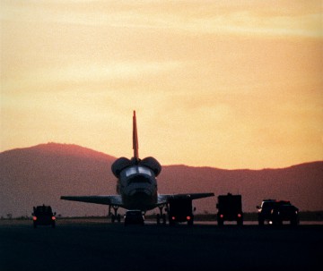 Backdropped by a Californian sunset, Discovery is approached by recovery vehicles shortly after landing. Photo Credit: NASA
