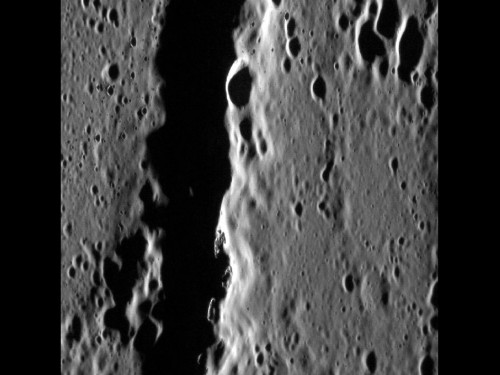 A close-up view of "hollows" on Mercury. The sharp walls and well-defined features of these enigmatic geologic formations, stand out against the muted background terrain, indicating they are substantially younger than their surroundings.