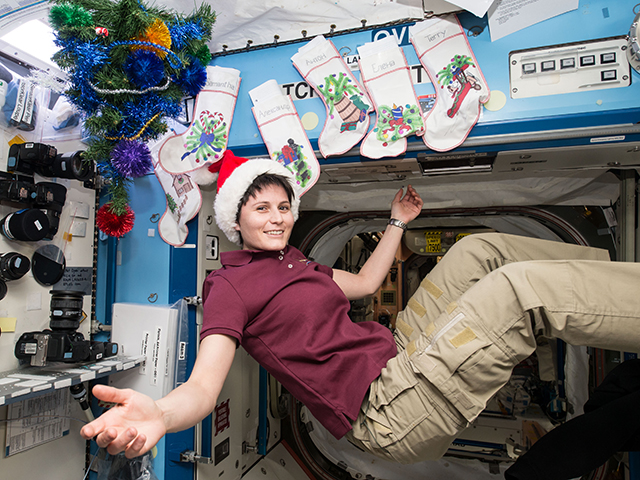 Italian astronaut Samantha Cristoforetti is in the holiday spirit as the station is decorated with stockings for each crew member and a tree. Photo: NASA