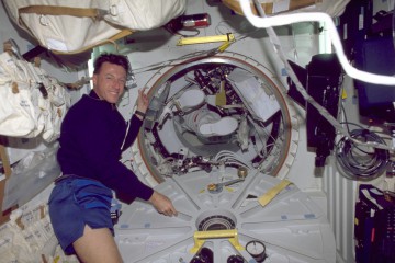 Mike Foale prepares to close the airlock hatch behind Steve Smith and John Grunsfeld, before one of STS-103's EVAs. Photo Credit: NASA