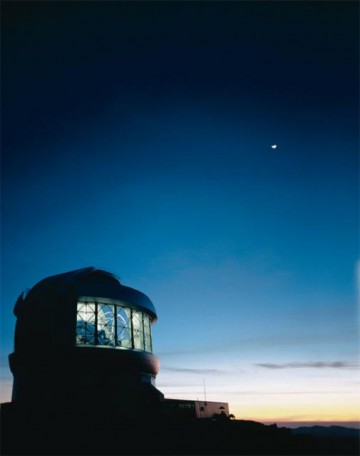 An exterior view of the Gemini South Telescope, below a crescent Moon. Image Credit: Gemini Observatory 