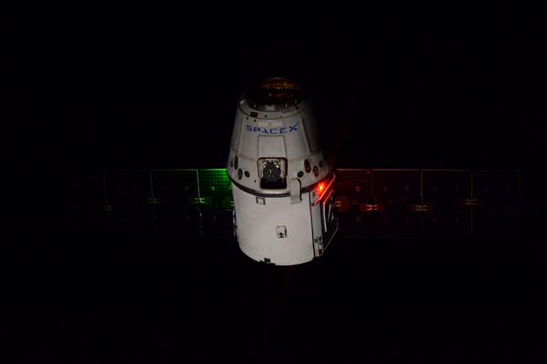 In a remarkable view of Dragon during its final approach, the greenish glow on the spacecraft's white surfaces and the red glimmer of its strobe lights reminded Samantha Cristoforetti of the national flag of her native Italy. Photo Credit: NASA/Terry Virts, via Twitter