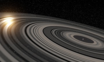 Artist’s conception of the ring system circling the young giant planet (or brown dwarf) J1407b. Image Credit: Ron Miller/University of Rochester