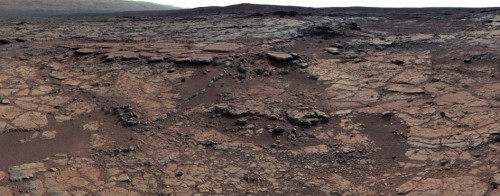 Curiosity image from Yellowknife Bay, where the potential microbial mat features were first seen in sandstone rocks. Gillespie Lake Member is the series of flat rocks in the central-left area of the image. Image Credit: NASA/JPL-Caltech/MSSS