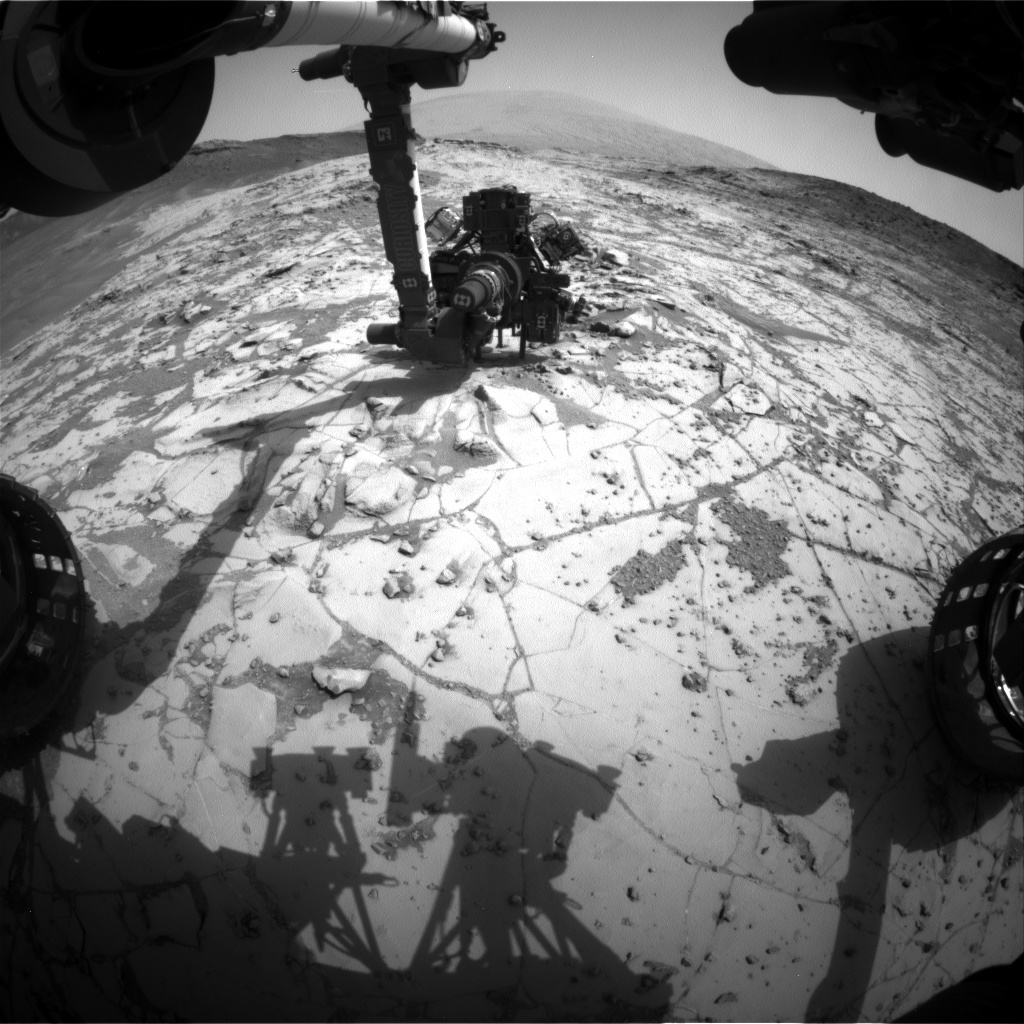 This view from the wide-angle Hazard Avoidance Camera on the front of NASA's Curiosity Mars Rover shows the rover's drill in position for a mini-drill test to assess whether a rock target called "Mojave" is appropriate for full-depth drilling to collect a sample. It was taken on Jan. 13, 2015.  Credit: NASA/JPL-Caltech