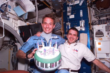 Jerry Linenger celebrated his 42nd birthday in space during STS-81, with an inflatable cake, courtesy of Marsha Ivins. He is pictured with crewmate Jeff Wisoff on Atlantis' middeck. Photo Credit: NASA, via Joachim Becker/SpaceFacts.de