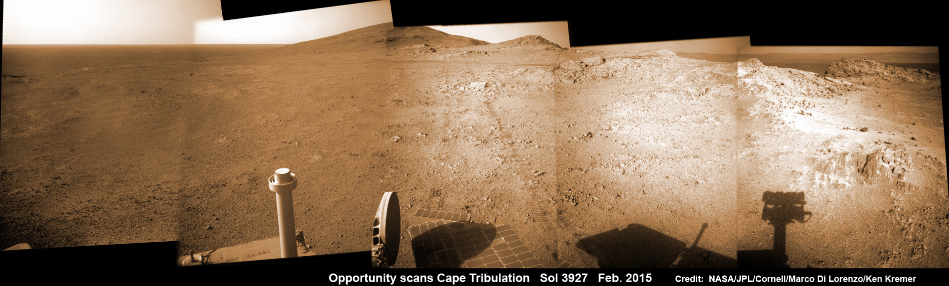 NASA Opportunity Rover scans back to summit of Cape Tribulation on Endeavour crater and overlooking crater rim while driving ahead to Martian science treasure at Marathon Valley on Feb. 10, 2015.  The rover operates well after 11 Years on Mars.   Note rover wheel tracks at center of this navcam camera photo mosaic assembled from images taken on Sol 3927 (Feb. 10, 2015) and colorized.  Credit: NASA/JPL/Cornell/ Marco Di Lorenzo/Ken Kremer/kenkremer.com