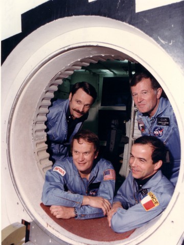 In the summer of 1984, following the cancellation of Mission 41F, Karol "Bo" Bobko (front left) received a French payload specialist, with Patrick Baudry (front right) and Jean-Loup Chretien (back right) selected to train for the position. Behind Bobko is Dave Griggs. All four men are framed by the side hatch of the shuttle simulator. Photo Credit: NASA, via Joachim Becker/SpaceFacts.de