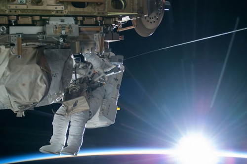 The Sun peeks above the limb of Earth, illuminating spacewalker Terry Virts during EVA-29. Photo Credit: NASA