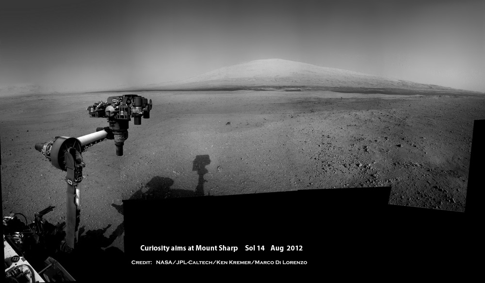 Curiosity points the way to Mount Sharp from Bradbury landing site - while raising arm for the first time.  This is the surface view from Curiosity’s landing location shown in GIF animation included herein.  This composite photo mosaic was stitched from navcam raw images taken through Sol 14, August 2012.   Featured at Astronomy Picture of the Day (APOD) on Aug 27, 2012.  Credit:  NASA/JPL-Caltech/Ken Kremer/kenkremer.com/Marco Di Lorenzo