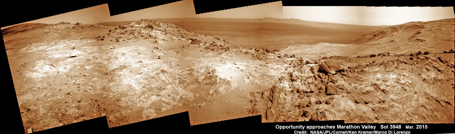 NASA’s Opportunity Rover scans along a spectacular overlook towards Marathon Valley on March 3, 2015 showing flat-faced rocks exhibiting a completely new composition from others examined earlier.  Marathon Valley and Martian cliffs on Endeavour crater hold deposits of water altered clay minerals.  This navcam camera photo mosaic was assembled from images taken on Sol 3948 (March 3, 2015) and colorized.  Credit: NASA/JPL/Cornell/Ken Kremer/kenkremer.com/Marco Di Lorenzo