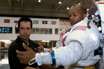 Bill Oefelein (left) assists Bob Curbeam with the final touches on a training version of his suit, prior to STS-116 EVA preparations. Photo Credit: NASA