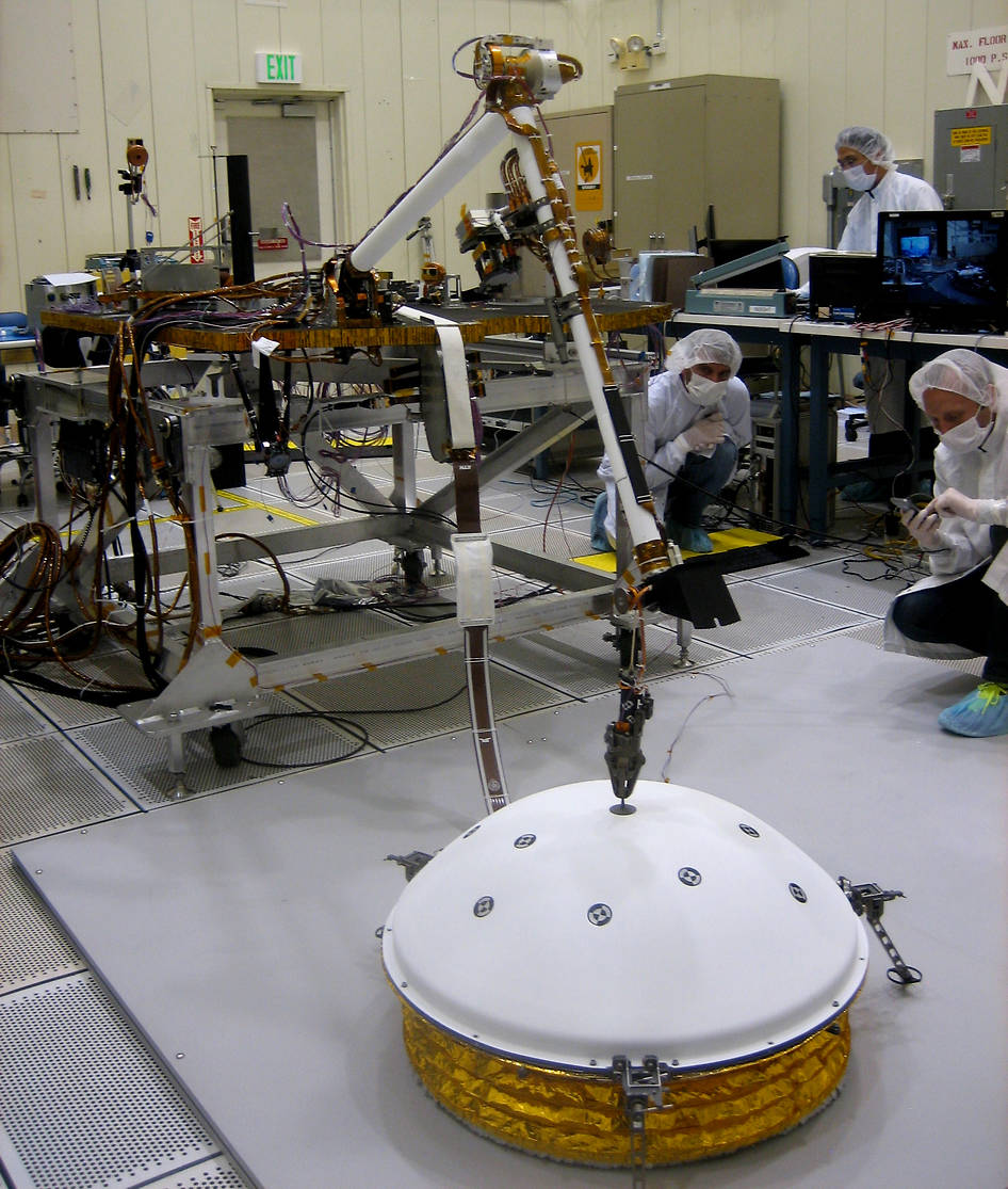 In the weeks after NASA's InSight mission reaches Mars in September 2016, the lander's arm will lift two science instruments off the deck and place them onto the ground. This image shows testing of InSight's robotic arm at JPL about two years before it will perform these tasks on Mars.  Credit: NASA/JPL-Caltech 