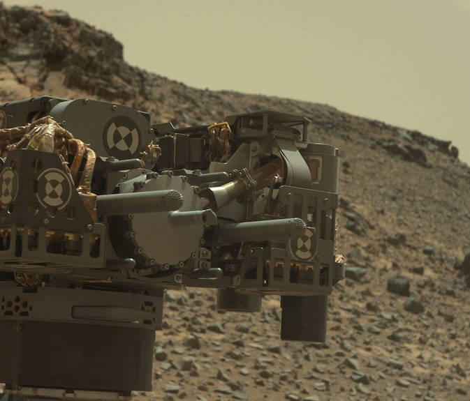 This raw-color view from Curiosity's Mastcam shows the rover's drill just after finishing a drilling operation at "Telegraph Peak" on Feb. 24, 2015.  Credit:  NASA/JPL-Caltech/MSSS