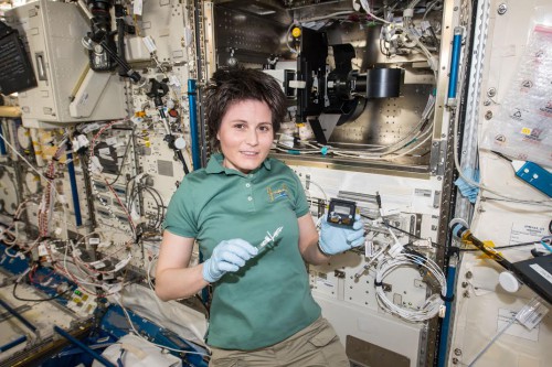 European Space Agency astronaut Samantha Cristoforetti holds a sample from the Japan Aerospace Exploration Agency's Aniso Tubule investigation on the International Space Station. Photo Credit: NASA