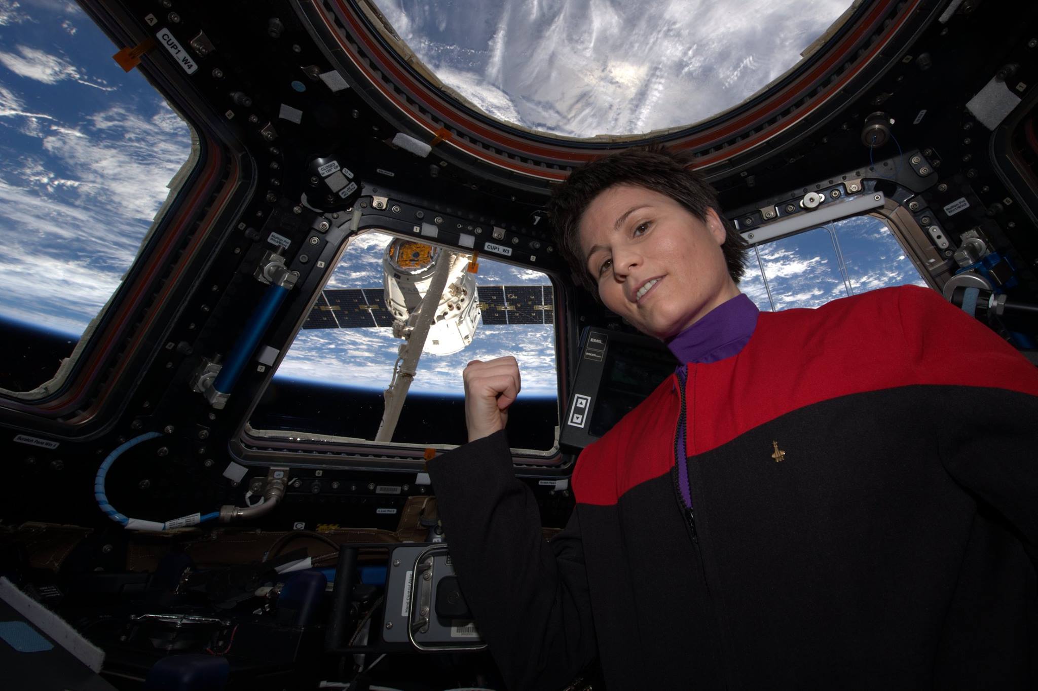Italian astronaut Samantha Cristoforetti, of the European Space Agency (ESA), poses with the SpaceX CRS-6 Dragon in her Starfleet outfit after successfully capturing the cargo and supply-filled spacecraft. Photo Credit: NASA/ESA