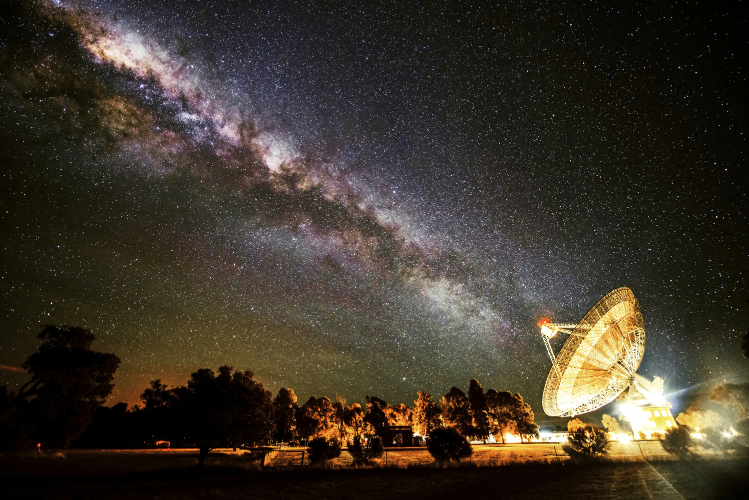 A dramatic night-time image of the 64-m Parkes radio telescope in Australia, under the splenor of the Milky Way. The iconic telescope has detected during the last decade a total of 10 mysterious cosmic radio flashes, known as 'fast radio bursts'. A new study now suggests that these astrophysical sources exhibit a surprising and unexpected mathematical pattern, which, if proven true,  could provide great insights on the nature of our Universe. Image Credit: Wayne England/CSIRO
