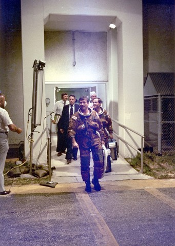 Commander John Young leads Pilot Bob Crippen out of the Operations & Checkout (O&C) Building for the first shuttle mission. Both men are clad in U.S. Air Force high-altitude pressure suits, which were worn by the first four shuttle crews. Photo Credit: NASA, via Joachim Becker/SpaceFacts.de