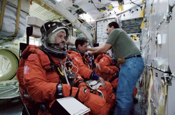 Thomas (center) trains in the shuttle mockup trainer for his duties during ascent on STS-113. A few months after this photograph was taken, he was grounded and replaced on Expedition 6 by his backup, Don Pettit. Photo Credit: NASA