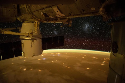 The setting sun turns Earth gold as cities fly by underneath and sparkling stars overhead, spreading out from the ISS. NASA astronaut Terry Virts posted this image, calling the star clusters in the center and to the right Magellanic clouds which are dwarf galaxies seen from the southern hemisphere. Photo Credit: NASA