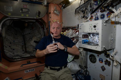 Expedition 43 crew member and NASA astronaut Scott Kelly getting hs first dose of "space coffee". Photo Credit: Twitter via @StationCDRKelly