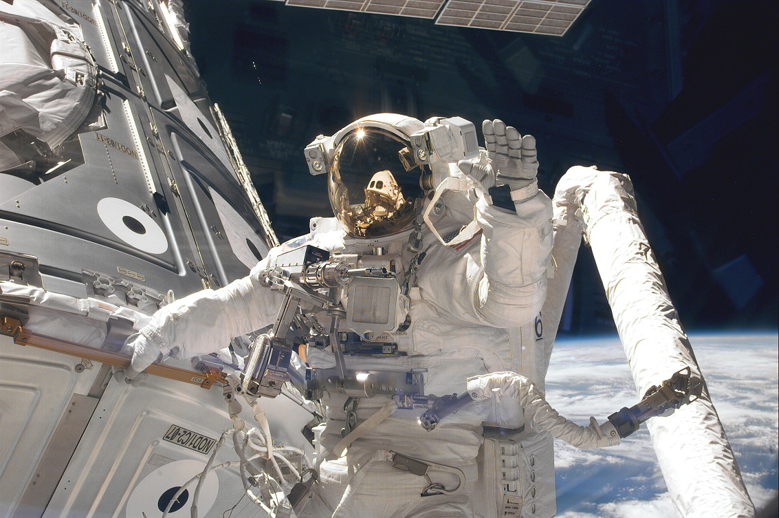 Jim Newman waves to Jerry Ross' camera whilst working outside the Unity node on STS-88. Photo Credit: NASA