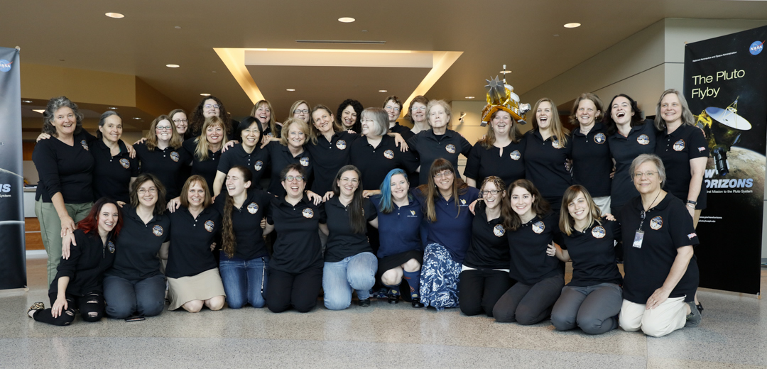 The women of the New Horizons team, photographed at Johns Hopkins University Applied Physics Laboratory on July 11, 2015, just three days before the spacecraft’s closest approach to Pluto. Kneeling from left to right: Amy Shira Teitel, Cindy Conrad, Sarah Hamilton, Allisa Earle, Leslie Young, Melissa Jones, Katie Bechtold, Becca Sepan, Kelsi Singer, Amanda Zangari, Coralie Jackman, Helen Hart. Standing, from left to right: Fran Bagenal, Ann Harch, Jillian Redfern, Tiffany Finley, Heather Elliot, Nicole Martin, Yanping Guo, Cathy Olkin, Valerie Mallder, Rayna Tedford, Silvia Protopapa, Martha Kusterer, Kim Ennico, Ann Verbiscer, Bonnie Buratti, Sarah Bucior, Veronica Bray, Emma Birath, Carly Howett, Alice Bowman. Not pictured: Priya Dharmavaram, Sarah Flanigan, Debi Rose, Sheila Zurvalec, Adriana Ocampo, Jo-Anne Kierzkowski. Photo Credit: Michael Soluri