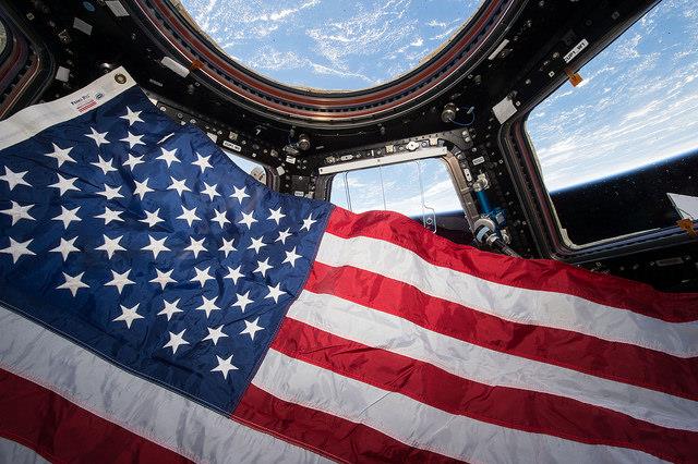 The Stars and Stripes floats inside the multi-windowed cupola of the International Space Station (ISS). Photo Credit: NASA