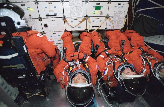 In the pre-Columbia era, returning ISS expedition crews occupied recumbent seats in the shuttle's middeck. In this training image from November 2002, STS-114 Mission Specialist Soichi Noguchi (left) is seated in an upright position, whilst Expedition 7 crew members Aleksandr Kaleri, Yuri Malenchenko and Ed Lu recline in the recumbent seats. Photo Credit: NASA